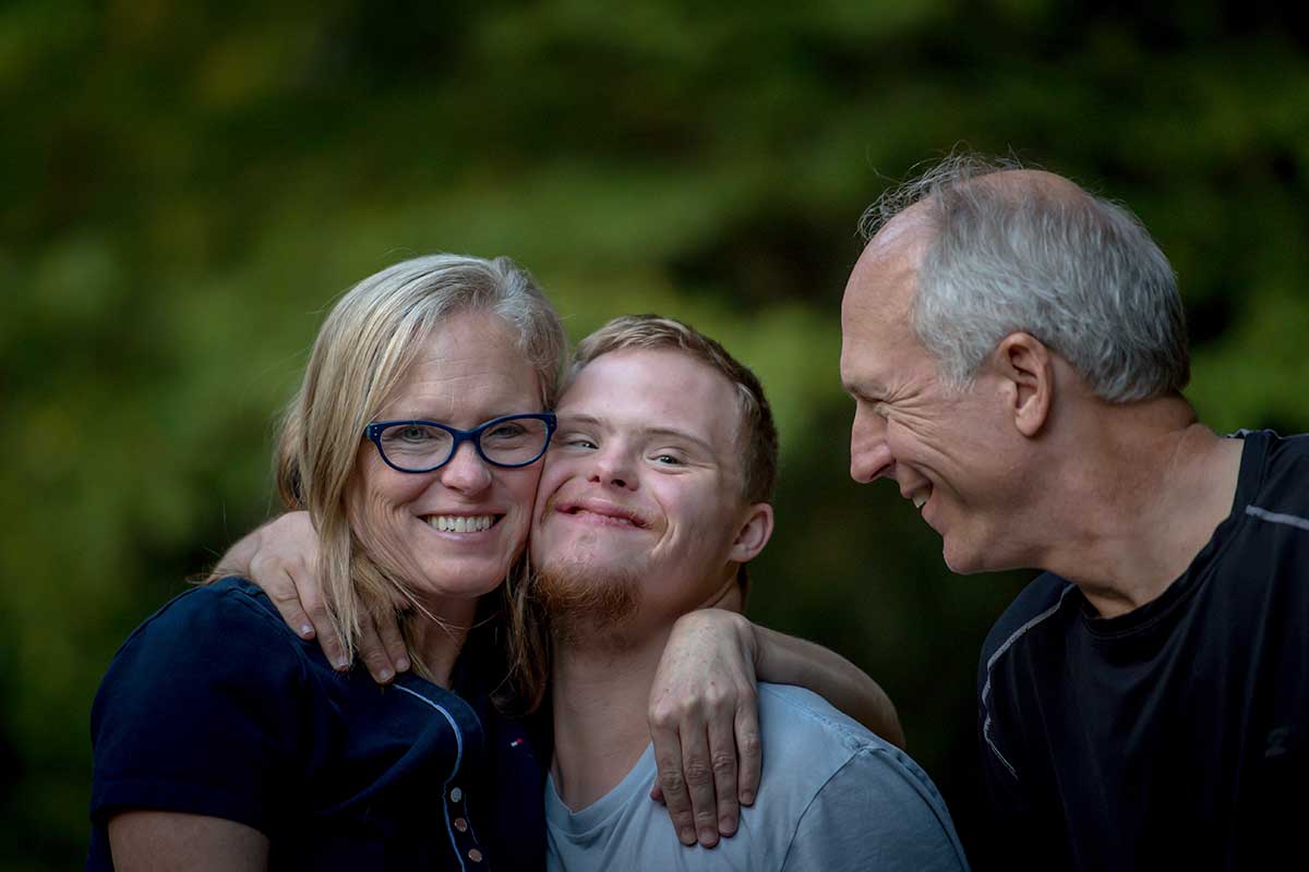 Image of man with Downs Syndrome and his parents